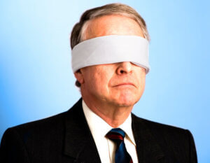 A senior businessman with a blindfold on.