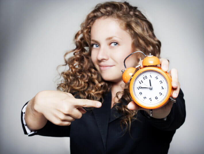 Young,Businesswoman,Holding,A,Clock